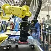 Gelber Roboterarm mit Saugnapf-Greifer und Metall-Werkstück in Demonstration von Montage- und Handhabungs-System bzw. Positionsiersystem auf Automatica 2022 von Schunk